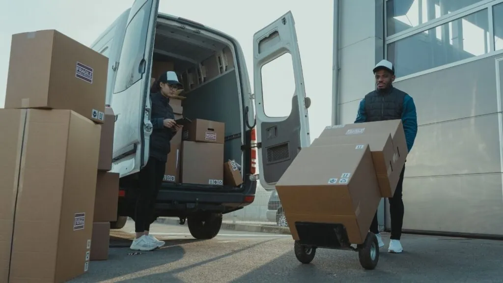 Transportadora: homens descarregando furgão.